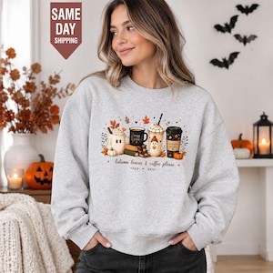 Może przedstawiać: Jasnoszara bluza z okrągłym dekoltem z nadrukiem graficznym przedstawiającym cztery kubki do kawy, książki i dynie z napisem Autumn leaves & coffee please. Wzór zawiera kubek w kształcie ducha, czarny kubek oraz kubek z kawą mrożoną.