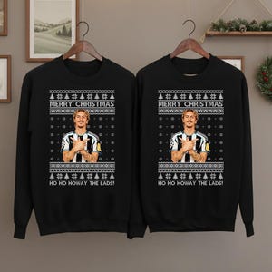 Puede incluir: Dos sudaderas negras con un diseño festivo. Cada una presenta un retrato de una persona, el texto "MERRY CHRISTMAS" y la frase "HO HO HOWAY THE LADS!" en blanco. El diseño incluye motivos de árboles de Navidad y copos de nieve.