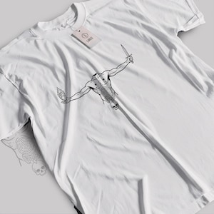 May include: White t-shirt featuring a black and white graphic of a headless figure holding a dagger and a flame. The figure has a spiral design on the torso and a skull at the bottom. A tag with the word "LANCE" is attached.