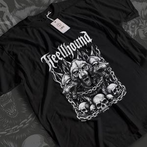 Könnte beinhalten: Schwarzes T-Shirt mit einer detaillierten Grafik eines dreiköpfigen Wolfes, der an Schädeln gefesselt ist, mit dem Wort "Heellhound" in gotischer Schrift. Das Shirt hat ein Etikett mit der Aufschrift "Large".