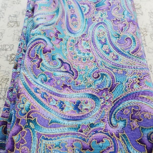 May include: Purple and teal paisley fabric with a gold metallic thread woven into the design.