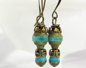 May include: A pair of dangle earrings with turquoise and green glass beads and gold-toned metal accents.