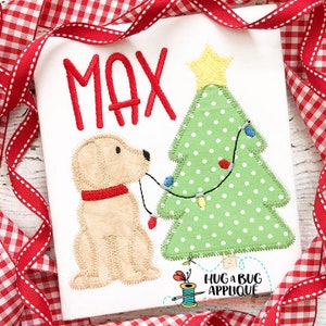 May include: A white applique design featuring a yellow star on top of a green Christmas tree with white polka dots and red and white lights. A yellow dog with a red collar is pulling on the lights. The name "MAX" is stitched in red above the tree.