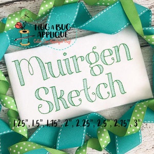 May include: A white fabric with green embroidery of the name "Muirgen Sketch" in a cursive font. The fabric is surrounded by turquoise and green ribbon with white polka dots. The text "1.25", "1.5", "1.15", "2", "2.25", "2.5", "2.15", and "3" is printed below the embroidery.