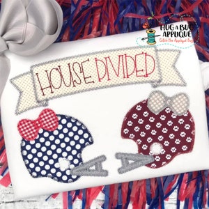May include: A white fabric applique with the text "HOUSE DIVIDED" in red embroidery. Two football helmets are on either side of the banner. The helmet on the left is blue with white polka dots and a red and white gingham bow. The helmet on the right is maroon with white paw prints and a tan bow.