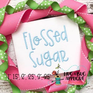May include: A white square with the words "Flossed Sugar" in light blue script, surrounded by pink and green polka dot ribbons. The text "1" 1.5" 2" 2.5" 3" 3.5" is below the text. The Hug A Bug Applique logo is in the bottom right corner.