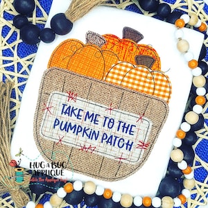 May include: A burlap bag filled with orange pumpkins with a white and orange checked pumpkin on top. The bag has a sign that says "Take Me To The Pumpkin Patch".