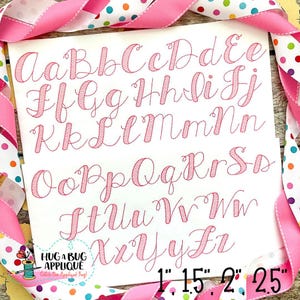 May include: A set of pink cursive alphabet letters in various sizes, from 1 inch to 2.5 inches. The letters are embroidered on a white background.