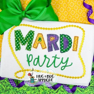 May include: A white fabric applique with the words "Mardi Party" in colorful, embroidered letters. The letters are outlined in yellow and have a polka dot, checkered, and striped pattern. The applique is surrounded by a yellow beaded border.