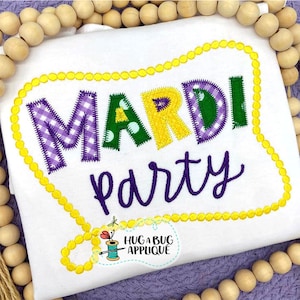 May include: A white shirt with a purple, green, and yellow applique that says "Mardi Party" in a yellow beaded frame.