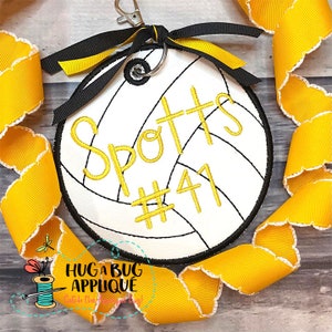 Peut inclure: Un ballon de volley-ball blanc avec des coutures noires et du texte jaune. Le texte indique "Spotts #41". Le ballon de volley-ball est attaché à un ruban jaune et un porte-clés.
