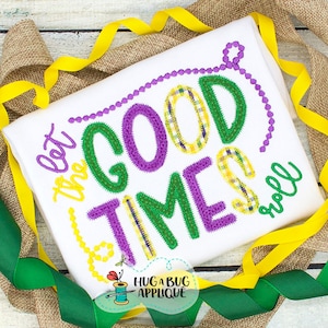 May include: White embroidered shirt with the text "Let the good times roll" in green and purple lettering with a beaded border. The shirt is surrounded by green and yellow ribbon.