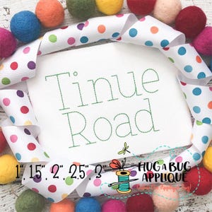 May include: White fabric with a green stitched design that says "Tinue Road" with a small dragonfly design. The fabric is surrounded by a white ribbon with colorful polka dots. The text "1", "1.5", "2", "2.5", "2" is visible at the bottom of the image. The text "Hug a Bug Applique" is visible in the bottom right corner of the image.