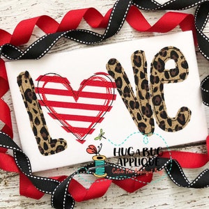 May include: A white fabric with the word "LOVE" in brown and black leopard print letters. The "O" is replaced with a red and white striped heart.