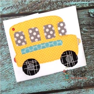 May include: A yellow school bus applique with black and white polka dot windows, a blue and white striped band, and black and white checkered wheels.