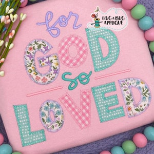 May include: A pink fabric applique with the text "for God so loved" in a variety of colorful fabrics and stitches.