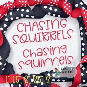 May include: Red and black polka dot ribbon surrounds a white fabric with red embroidered text that reads "Chasing Squirrels" in two different sizes. The text is in a handwritten font. The image also includes a small logo with the text "Hug a Bug Applique".