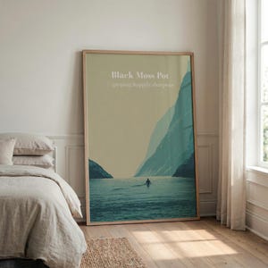 May include: A large rectangular framed wall art print featuring a landscape of a calm body of water between two dark mountains. The text Black Moss Pot and gasping.happily.sharpens is printed in white at the top centre of the muted green sky.