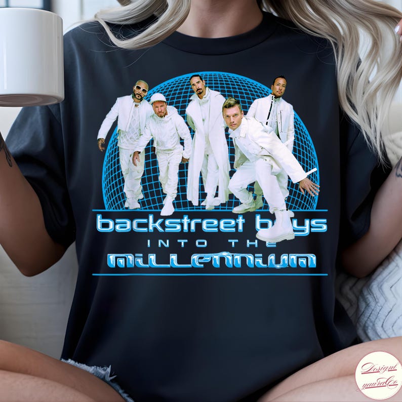 May include: A black t-shirt featuring a graphic of the Backstreet Boys in white outfits standing in front of a blue grid sphere. The text reads "backstreet boys" and "INTO THE MILLENNIUM" in a stylized blue font below the group image.