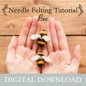 Könnte beinhalten: Eine digitale Download-Anleitung zum Nadelfilzen einer Biene. Zwei kleine gefilzte Bienen sind auf dem Bild zu sehen, eine in jeder Hand. Die Bienen sind gelb und schwarz mit weißen Flügeln.