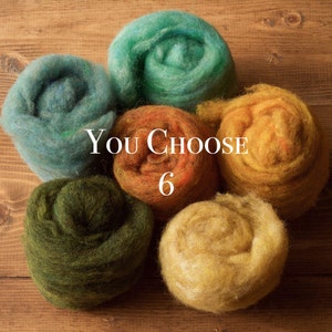 May include: Six balls of yarn in various colors, including teal, blue, orange, green, and yellow. The balls are arranged in a circle on a wooden surface. The text "You Choose 6" is printed on the image.