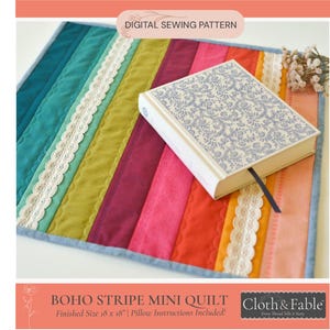 Peut inclure: Un mini-patchwork Boho Stripe coloré avec un livre. Le patchwork présente des rayures verticales dans les tons de turquoise, vert, violet, rose, orange et jaune, avec une bordure en dentelle blanche. Le livre a un motif floral bleu. Le texte "DIGITAL SEWING PATTERN" est en haut.