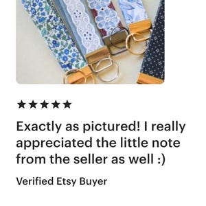 May include: A collection of fabric key fobs in various patterns, including floral and lace designs. Each fob features a gold-toned metal clasp for attaching keys. The image shows a variety of colors, including blue, white, and burgundy.