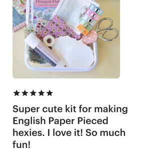 May include: A clear plastic container filled with craft supplies for English Paper Piecing. Includes fabric, scissors, clips, glue, and paper pieces. The kit is labeled "Hexagon Flower".