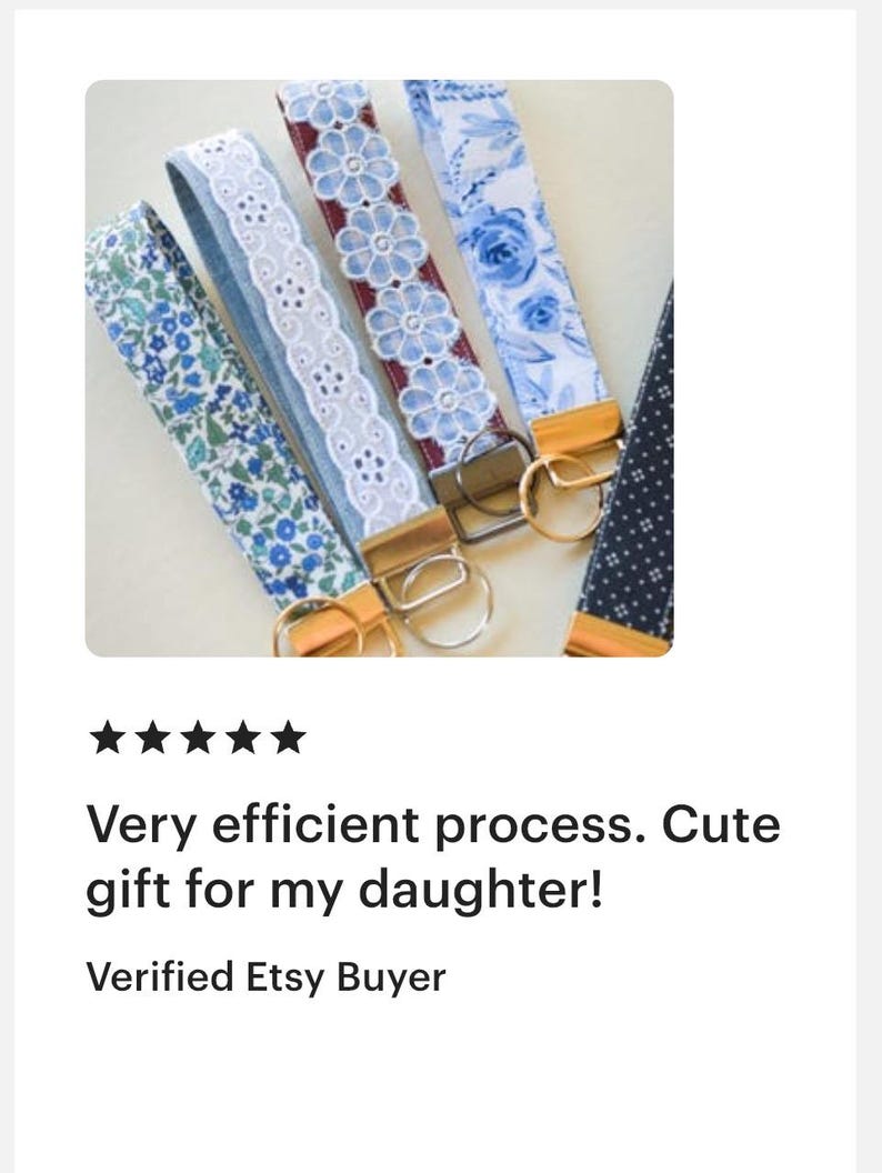 May include: Close-up of several key fobs with various floral and lace patterns in shades of blue and white. Each fob has a gold-colored metal clasp and ring. The image includes text that reads "Very efficient process. Cute gift for my daughter!"