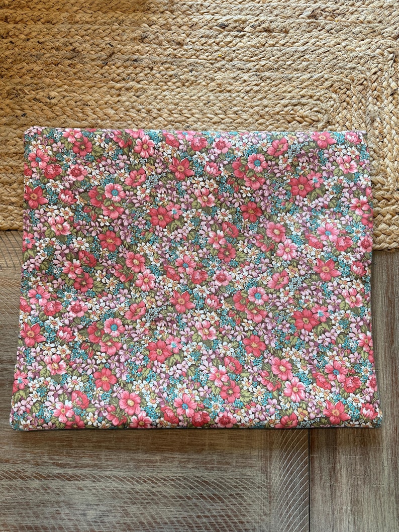 Pode incluir: Um tecido retangular com um padr&atilde;o floral denso. O design apresenta pequenas flores vibrantes em tons de rosa, vermelho e branco, sobre um fundo verde e azul. O tecido &eacute; provavelmente algod&atilde;o ou um material semelhante.