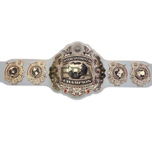 May include: A gold and silver Intercontinental Champion wrestling belt. The belt features a large central plate with the words "Intercontinental Champion" and a globe design. Smaller plates with globe designs are on each side.