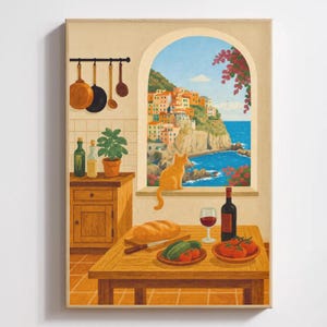 Puede incluir: Una impresión artística enmarcada representa una escena de cocina con vista a un pueblo costero. Una mesa está puesta con pan, tomates y vino. Un gato naranja está sentado en el alféizar de la ventana. Ollas y sartenes cuelgan.