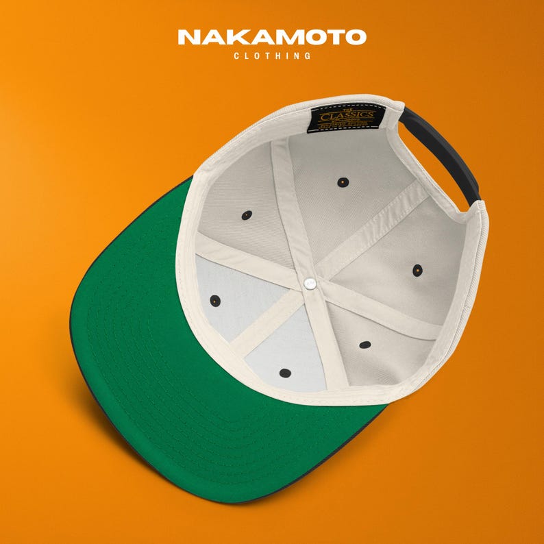 Puede incluir: Gorra de b&eacute;isbol con visera verde y correa negra. El interior es blanquecino con costuras negras y una etiqueta negra que dice "CLASSICS". La marca "NAKAMOTO CLOTHING" est&aacute; impresa en blanco.