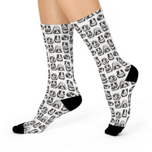 May include: White socks with a repeating pattern of black and white guinea pig illustrations. The socks have black heels and toes, and the guinea pig designs vary in expression and pose.