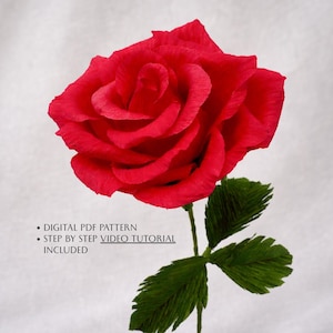 Puede incluir: Una rosa roja de papel con hojas y tallo verdes. La rosa está en plena floración, mostrando texturas detalladas de los pétalos. La imagen incluye el texto: "DIGITAL PDF PATTERN, STEP BY STEP VIDEO TUTORIAL INCLUDED."