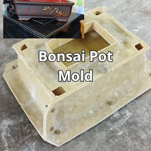 Może przedstawiać: Beżowa forma do doniczki bonsai z napisem "Bonsai Pot Mold" pośrodku. Forma ma kształt prostokątny z zagłębionym wnętrzem i kilkoma małymi kwadratowymi otworami. W tle widoczna jest ozdobna doniczka bonsai.