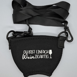Schwarzer Neopren-Weinflaschenhalter mit einem verstellbaren schwarzen Gurt und Clips. Der Halter hat den weißen Text "DU BIST EINFACH WeinZIGARTIG" und eine Weinglas-Grafik.