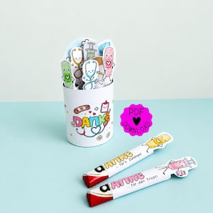 Op de afbeelding: Een witte cilindrische houder versierd met kleurrijke medische illustraties en het woord "DANKE" in veelkleurige letters, gevuld met papieren uitsparingen van medische items. Twee verpakte chocoladerepen bevatten soortgelijke medische afbeeldingen.