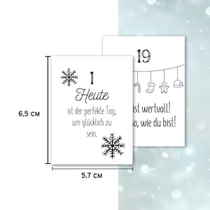 May include: Two white rectangular cards, 2.2 inches tall and 2.2 inches wide, with black text and snowflake designs. One card reads "1 Heute ist der perfekte Tag, um gl&uuml;cklich zu sein." The other card reads "19 ist wertvoll! so, wie du bist!"