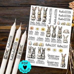 Könnte beinhalten: Drei weiße Kerzen und ein Bogen mit Ostern-Aufklebern. Die Kerzen sind mit Hasenillustrationen und dem Text "Frohe Ostern" verziert. Der Aufkleberbogen zeigt Hasenillustrationen, Blumen und Ostergrüße.