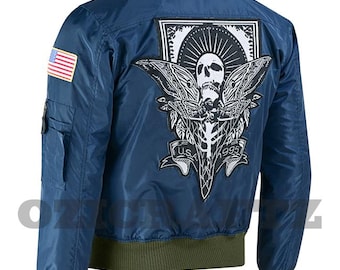 May include: A navy blue bomber jacket with a green collar, cuffs, and waistband. The back features a large patch with a skull and moth design, the text "USA 1995", and an American flag patch on the left sleeve.