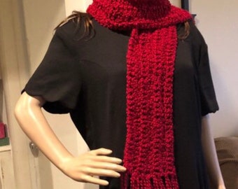 May include: A red crocheted hat and matching scarf with fringe. The hat is slouchy and the scarf is long.