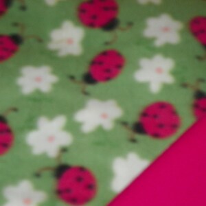 Manta para bebé Pink Ladybugs con respaldo rosa intenso. Doble forro polar cosido.