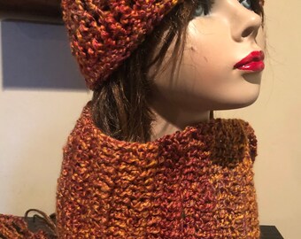 May include: A crocheted hat and scarf set in shades of orange, red, and brown. The hat is a slouchy beanie style and the scarf is a long, rectangular shape.