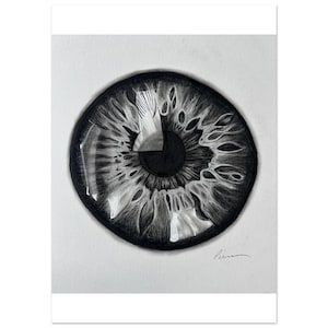 Puede incluir: Un dibujo al carboncillo en blanco y negro del iris y la pupila de un ojo humano. La obra presenta líneas radiales intrincadas y sombreados que crean profundidad, con un reflejo blanco prominente. Una firma es visible en la esquina inferior derecha.