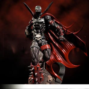 May include: A detailed figurine of the Spawn comic book character. The figure is predominantly black with red accents, including a flowing cape and spiked wristbands and boots. The character has a skull belt and chains, and stands on a rocky base with skulls.