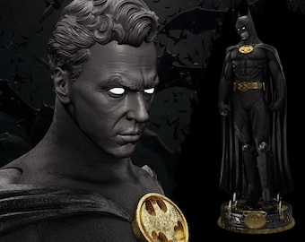 May include: A black and gold Batman statue and bust. The bust features a sculpted face with glowing white eyes and a gold Batman emblem. The statue is in a classic pose, with a black suit, cape, and gold belt. The background is dark with bat silhouettes.