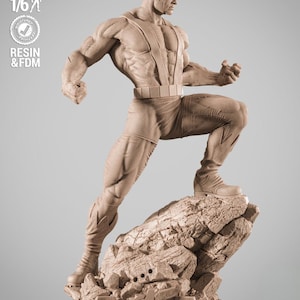 Puede incluir: Estatua de color beige de un superhéroe en una pose dinámica, de pie sobre una base rocosa con el logotipo de los Vengadores. La figura es muy detallada, con músculos definidos y un casco. La estatua está etiquetada como "SCALE 1/6" y "RESIN & FDM".