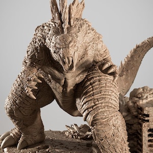 May include: A detailed, brown resin sculpture of a Godzilla-like monster, posed in a menacing stance. The figure has textured skin, sharp claws, and a spiky dorsal fin. The sculpture is 1/6 scale and includes the text "RESIN & FDM".