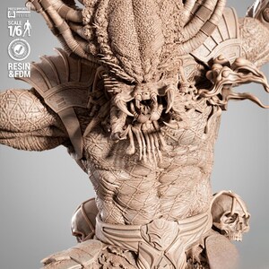 May include: A detailed, tan-colored Predator statue, showcasing intricate textures and design. The figure has a menacing expression with visible teeth and detailed armor. The statue is labeled as 1/6 scale and made of resin and FDM.